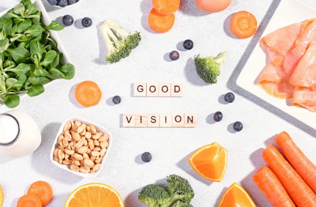 a number of foods including broccoli, blue berries, nuts, and orange quarters arranged around block letters spelling out good vision