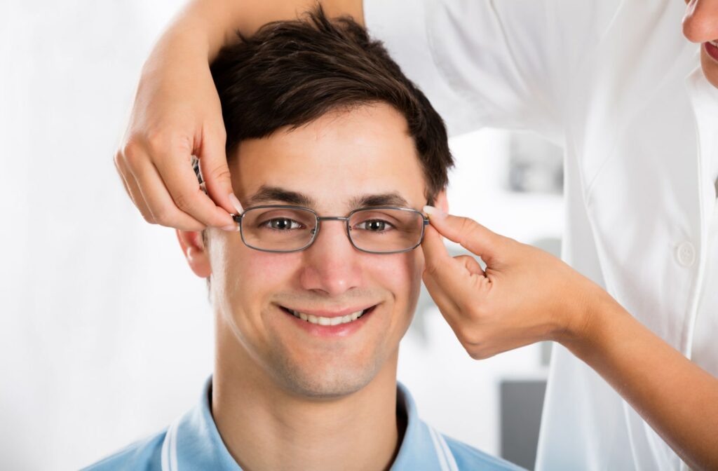 A close of up a man trying on his new glasses with the help of an optician.
