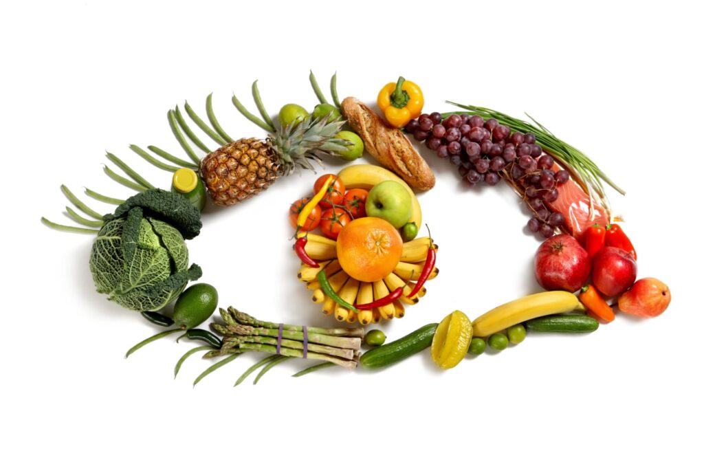 A variety of eye-healthy fruits and vegetables are shaped into an eye