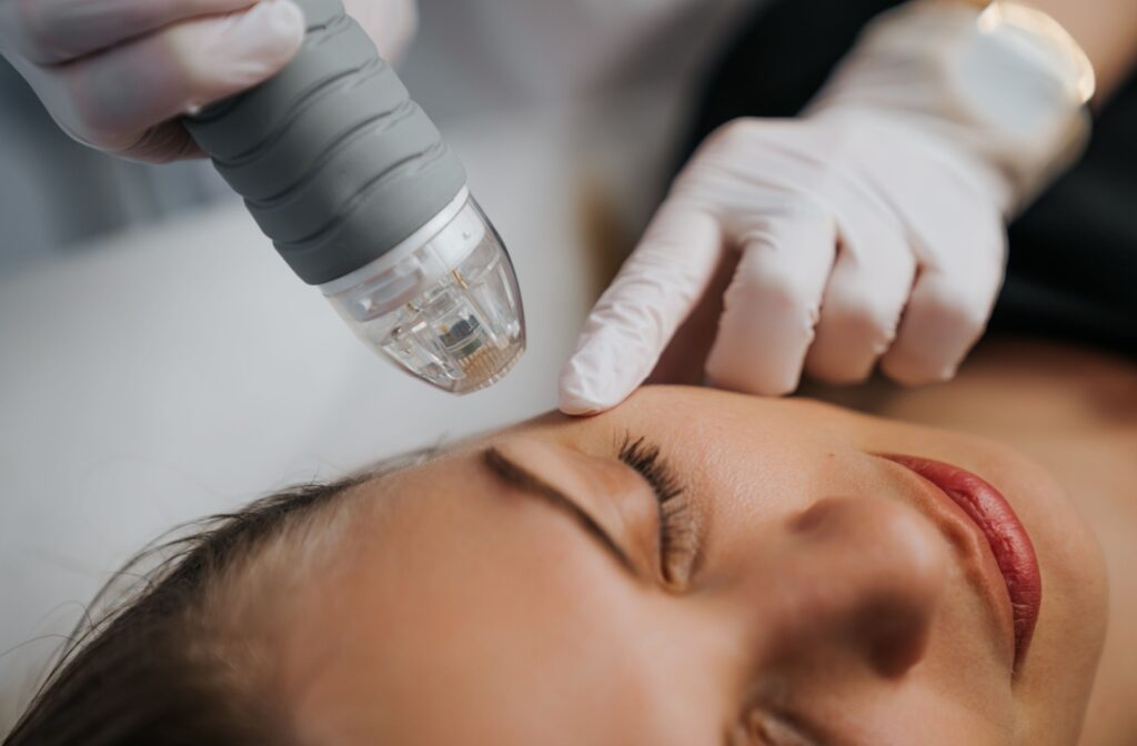A woman receives radiofrequency treatment from her optometrist using a handheld device
