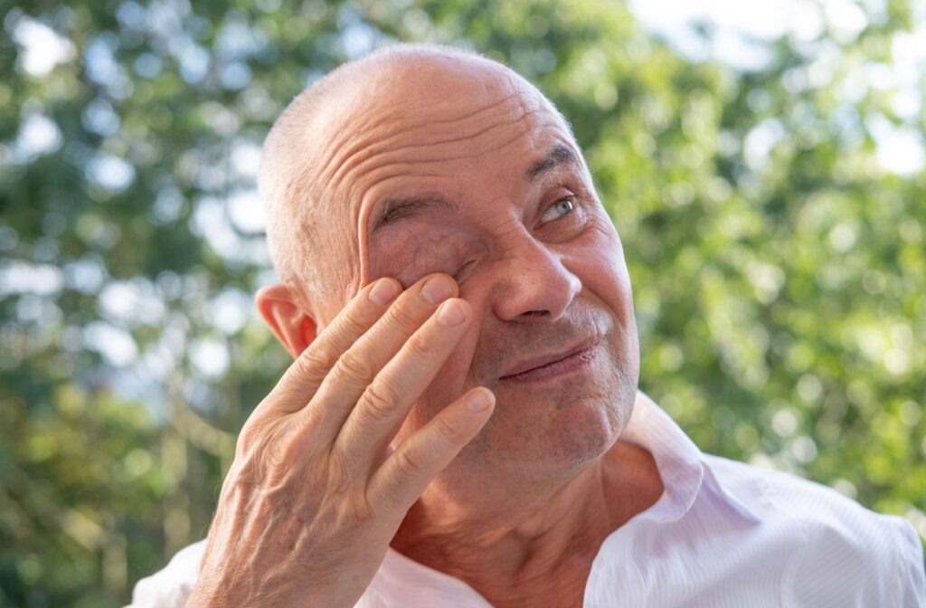 A senior man rubbing his eye, possibly experiencing discomfort, which can be a symptom of glaucoma