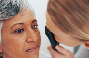 An older woman patient undergoes an eye exam, showcasing how optometrists assess vision and overall eye health.