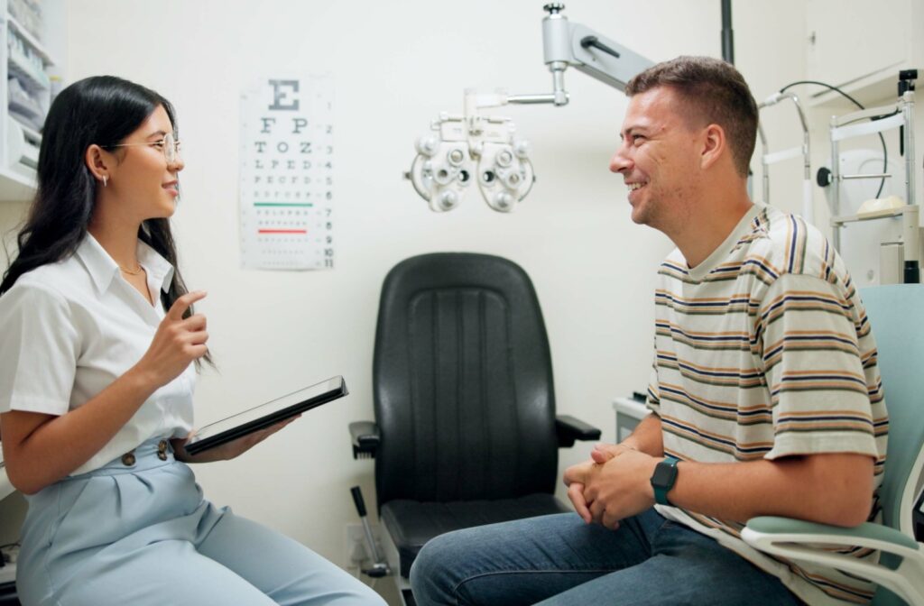 Young female optometrist and young male patient chatting in an optometry office.